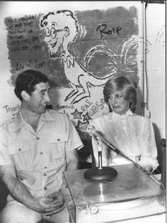 an old photo of two people sitting at a table with a record player in front of them