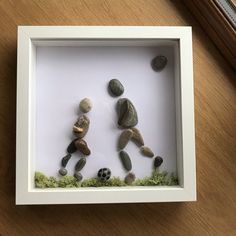 some rocks in a white frame on a table