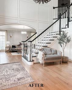 a living room filled with furniture and a stair case in front of a chandelier