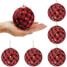 red and black christmas bauble ornament hanging from a person's hand