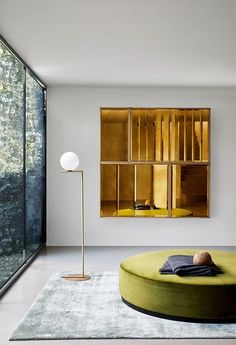 a living room filled with furniture and a large window next to a wall mounted painting