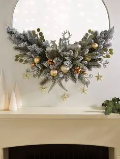 a fireplace mantel decorated with silver and gold christmas decorations