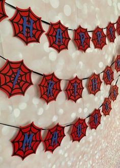 red and blue spider web banner hanging from the ceiling in front of a white wall