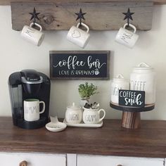 coffee mugs are hanging on the wall above a dresser with cups and other items