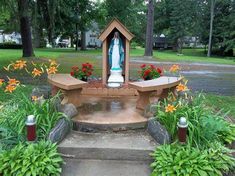 an outdoor shrine with flowers in the foreground and trees in the backgroud