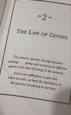 the law of giving is written on a piece of paper with an image of a person holding