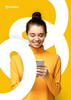 a woman smiles as she looks at her cell phone in front of the number six