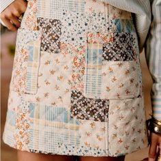 a close up of a woman's skirt with patchwork and floral patterns on it