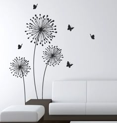 a living room with a white couch and black dandelion wall decals