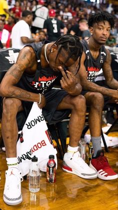 two basketball players sitting on the sidelines