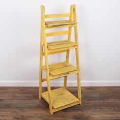 a yellow wooden shelf sitting on top of a hard wood floor