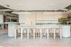 an open kitchen and dining area with bar stools