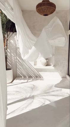 the sun is shining through the white curtains