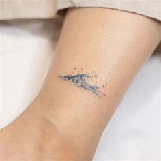 a small wave tattoo on the ankle