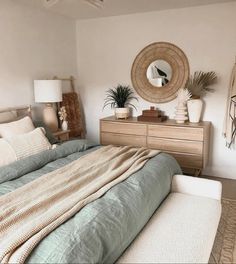 a bedroom with a bed, dressers and mirror in it's centerpiece