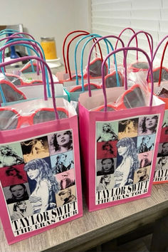 pink shopping bags with photos of taylor swift on them sitting on a table in a store