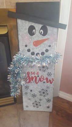 a snowman made out of tinsel on top of a fireplace