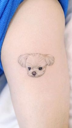 a small dog's face is shown on the thigh