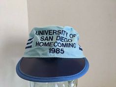 Up for sale is a Vintage University of San Diego Painters Cap. These hats were given out during Homecoming of 1985. It is marked Proudly Made In USA and has a great look to it. These hats are not easy to find! This hat would make an awesome addition to your collection! As far as condition goes, this hat is in Vintage New Old Stock Condition. However, it does show shelf wear consistent with age and storage which can be seen in the pictures provided including creasing to the cardboard bill which i Hat Design Ideas, Hat Packaging, 80s Hats, Show Shelf, Streetwear Caps, University Of San Diego, Dog Patch, Vintage University, Distressed Hat