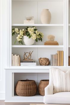 a white book shelf filled with books and vases