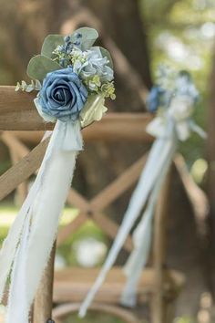 blue and white flowers are tied to the back of a chair with ribbons on it