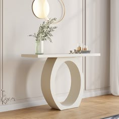 a white table with a vase on top of it next to a mirror and lamp