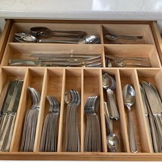 an open drawer with silverware in it