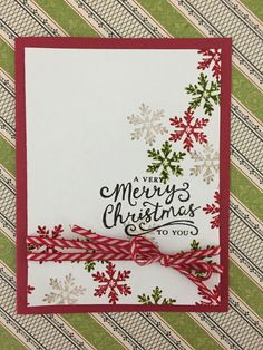 a merry christmas card with red and white ribbon on it, featuring snowflakes