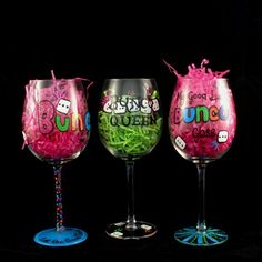 three wine glasses decorated with candy and candies in different designs, all sitting side by side on a black background