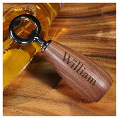 a bottle opener sitting on top of a wooden table next to a corkscrew