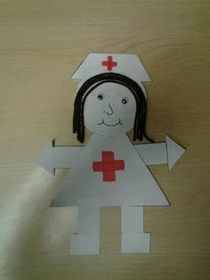 a paper cut out of a girl with a red cross on her chest and head