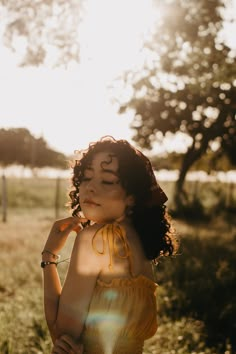 a woman with her eyes closed standing in the grass