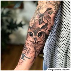 an owl tattoo on the left arm and right arm, with flowers around its neck