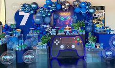 a video game themed birthday party with balloons and games on the wall, blue decorations