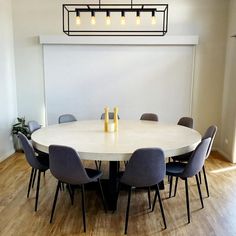 a dining room table with chairs and bottles on it in front of a white wall