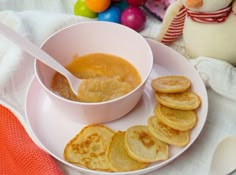 a white plate topped with pancakes next to a bowl of peanut butter