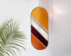 a mirror hanging from the side of a white wall next to a potted plant