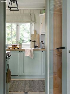 an open door leading to a kitchen with light blue cabinets