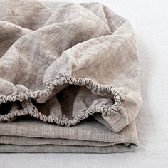 an unmade blanket with ruffled edges on a white surface