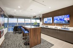 a large kitchen with two televisions on the wall