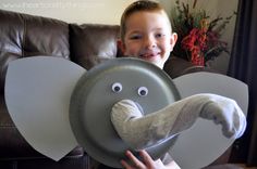 a young boy holding an elephant shaped plate