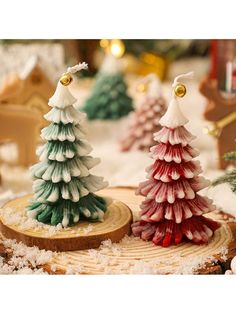 three small christmas trees on top of a wooden slice