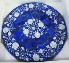 a blue plate with white flowers on it in a box