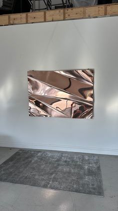 an abstract painting hangs on the wall next to a gray area rug in front of it