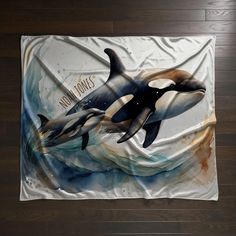 two orca killer whales swimming in the ocean on a beach towel, with words that say mom knows