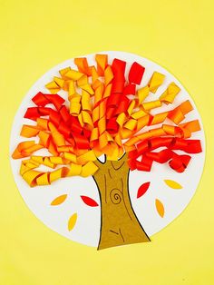 a paper plate with a tree made out of cut up pieces of colored paper on it