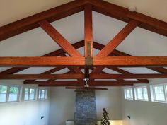 a living room filled with furniture and a fire place under a wooden beamed ceiling