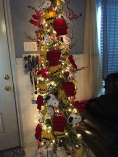 a decorated christmas tree in the corner of a room with lights and decorations on it