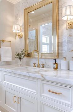 a bathroom with marble counter tops and gold fixtures