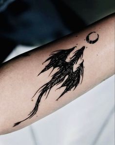 a woman's arm with a tattoo on it and a bird flying in the sky